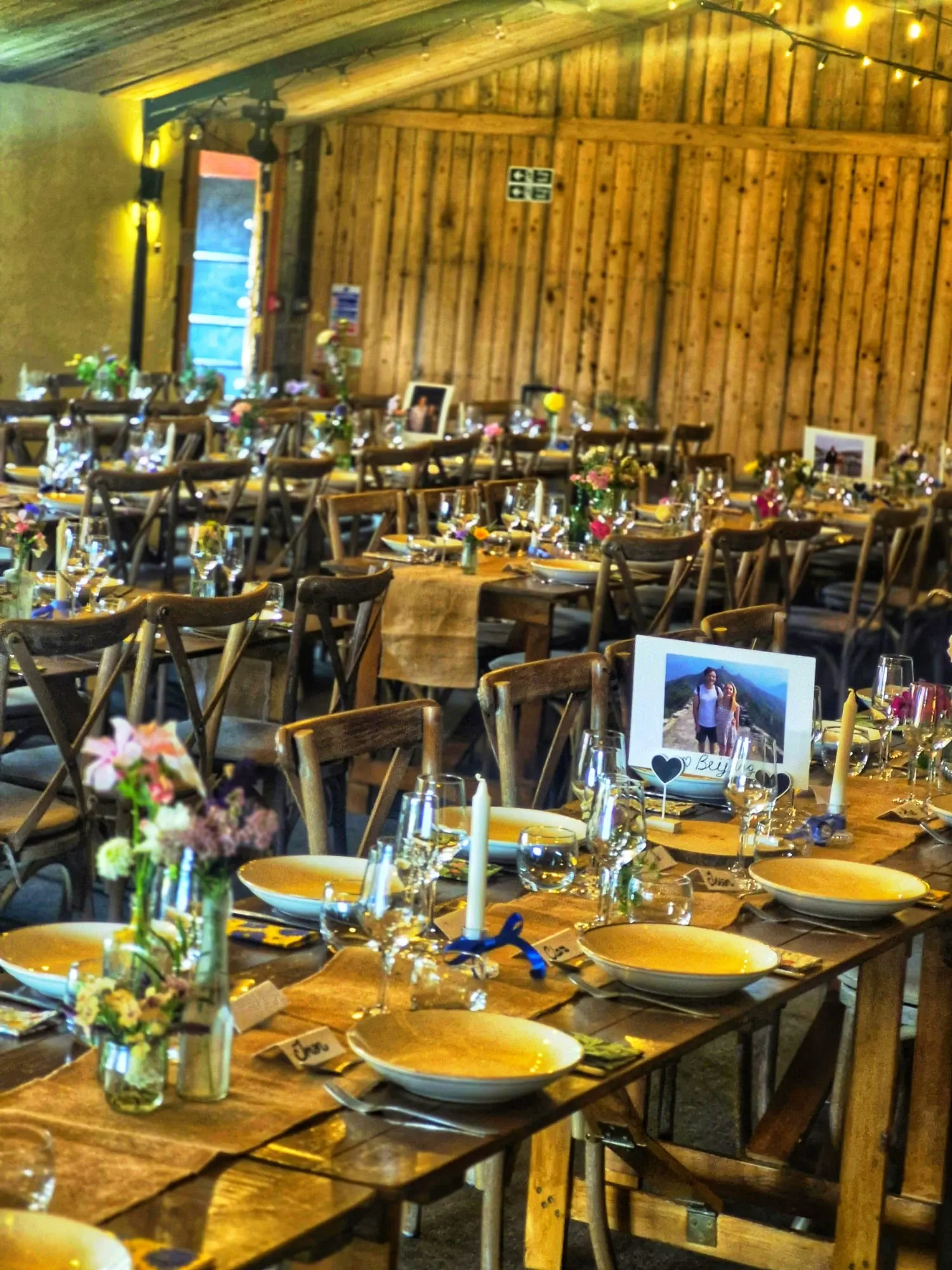 Barn wedding reception tables set for a Thai wedding breakfast