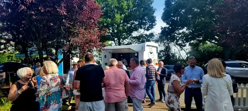 Guests queueing and chatting in front of the Fan Thai Sticks horse-box food van