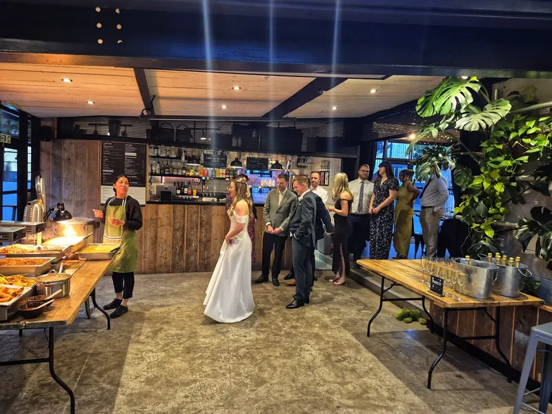 Bride and groom at their reception with the Fan Thai Sticks buffet set up behind them